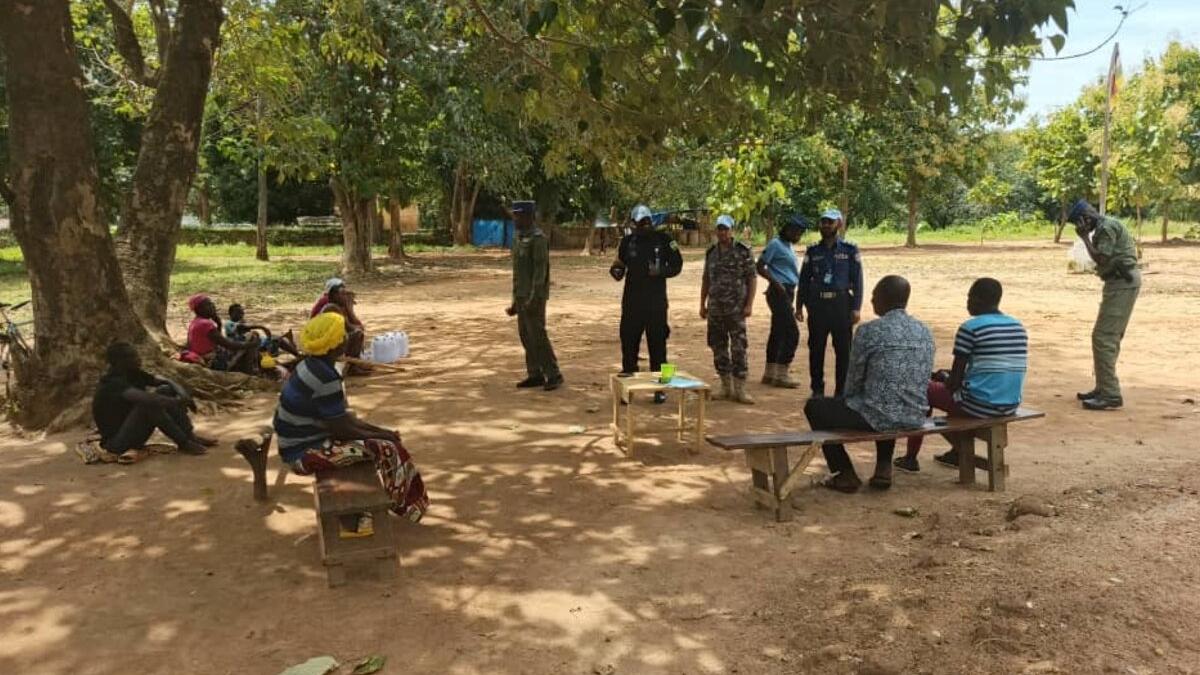 Des Casques bleus et des membres de la communauté tiennent une réunion sous un arbre