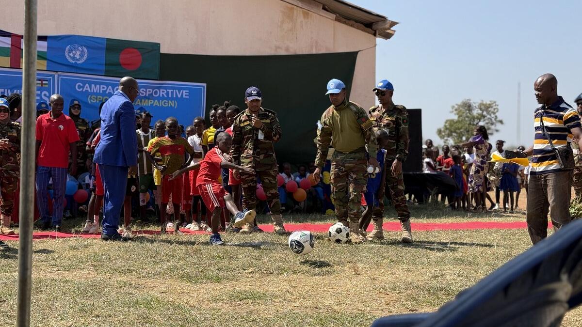 Des soldats de la paix et des membres de la communauté jouent au football
