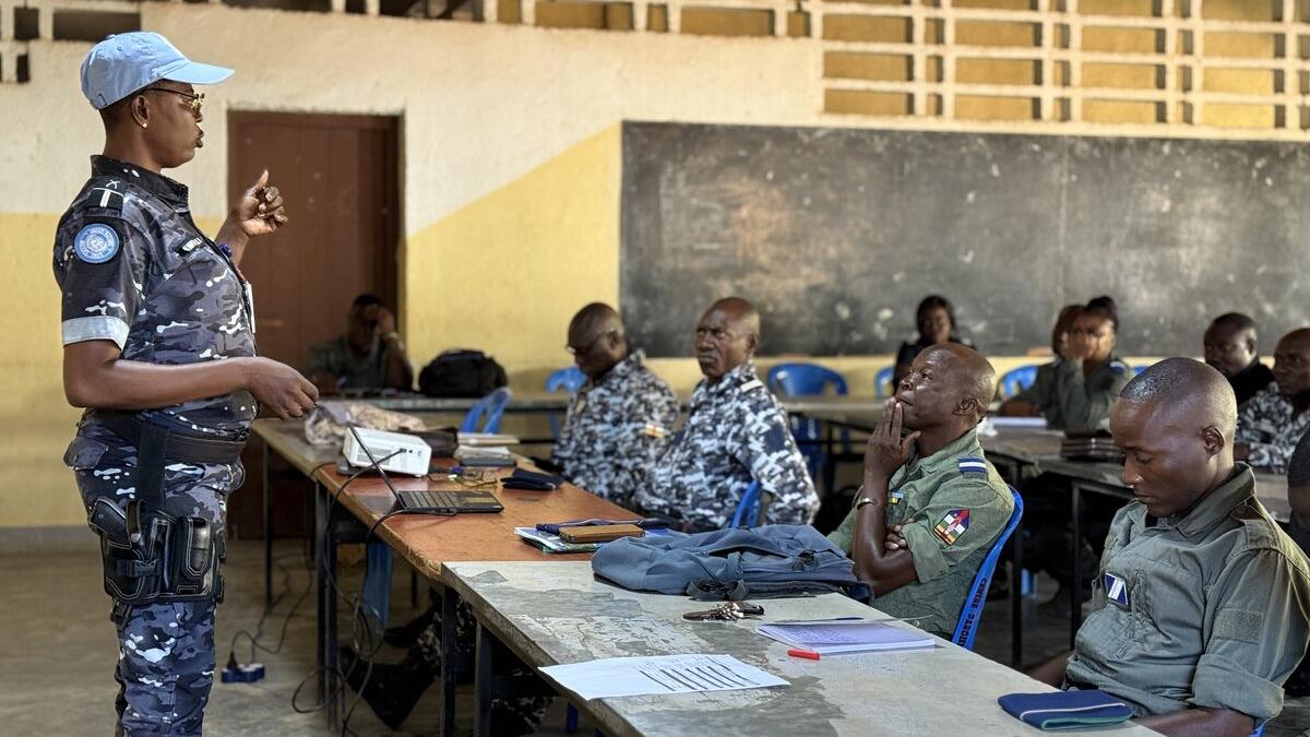 Une femme soldat de la paix en uniforme militaire s'adresse à une salle remplie de militaires.