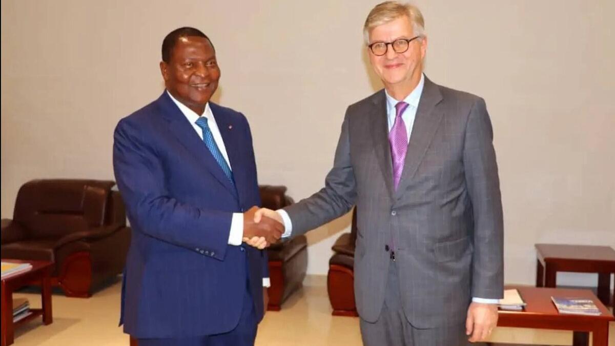 Deux hommes en costume se serrent la main.