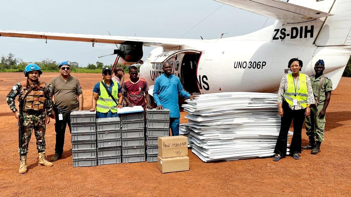Des Casques bleus de la MINUSCA se tiennent au sol à côté d'un avion de l'ONU