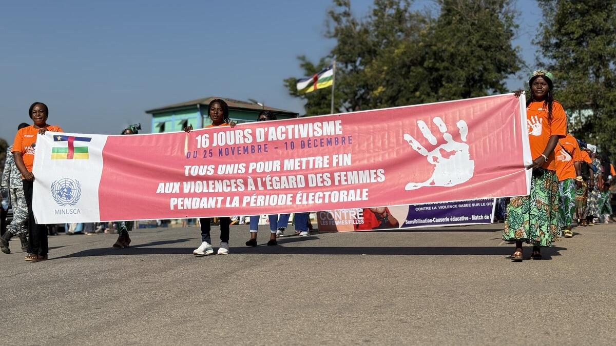 Des gens défilent avec une grande bannière