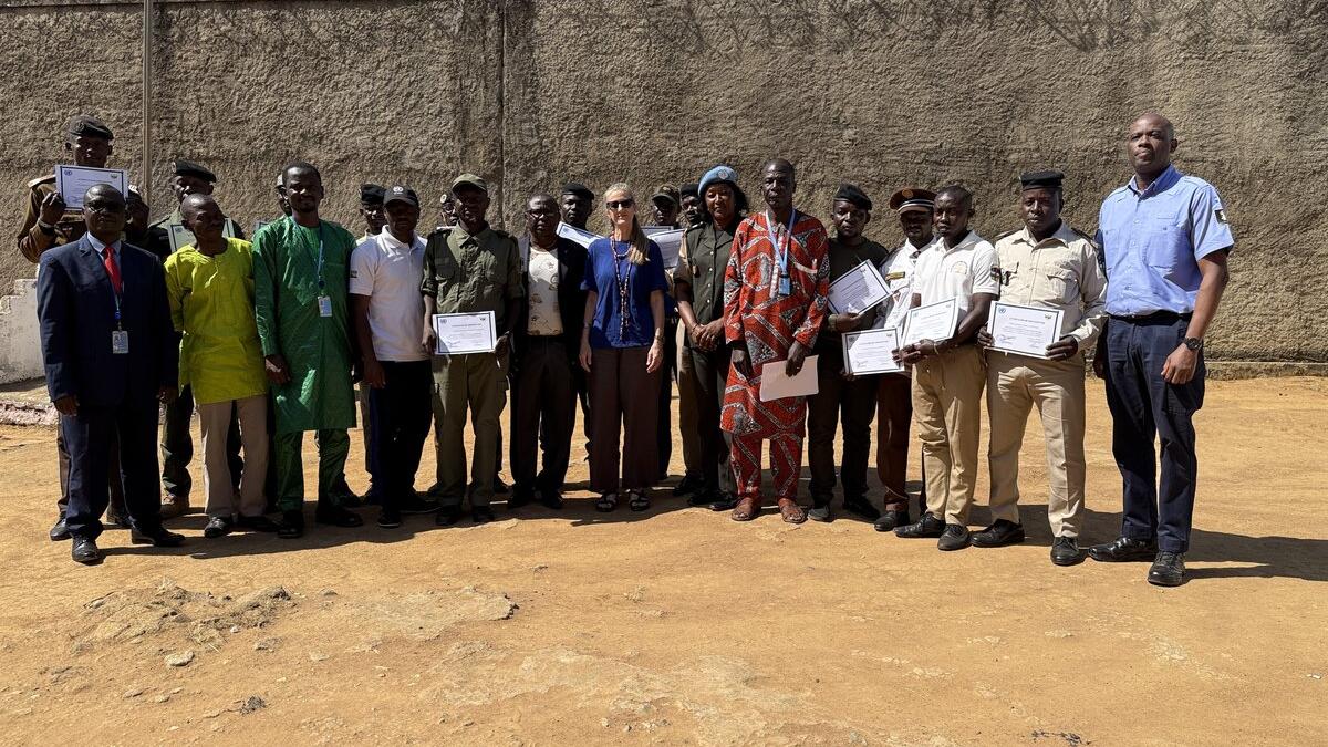 Un groupe de personnes se tient en rang, souriant à la caméra