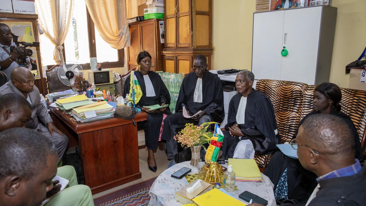 Des juges et un groupe de personnes sont assis dans un bureau et discutent.