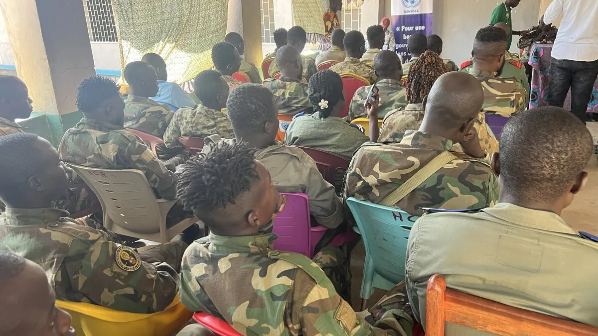 Des casques bleus sont assis pendant un événement. 