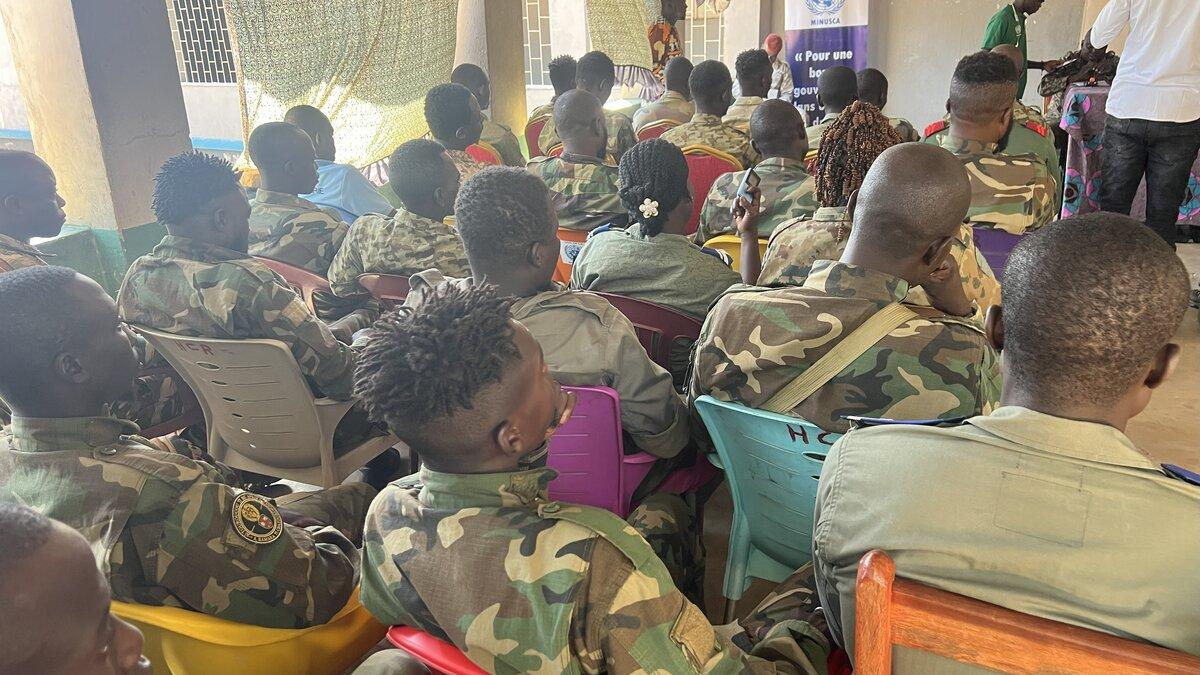 Des casques bleus sont assis pendant un événement. 