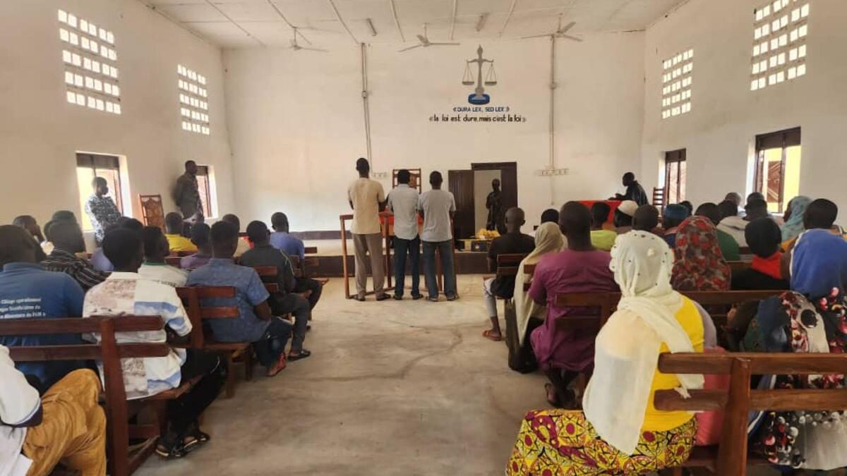 Un public est assis dans une salle d’audience.