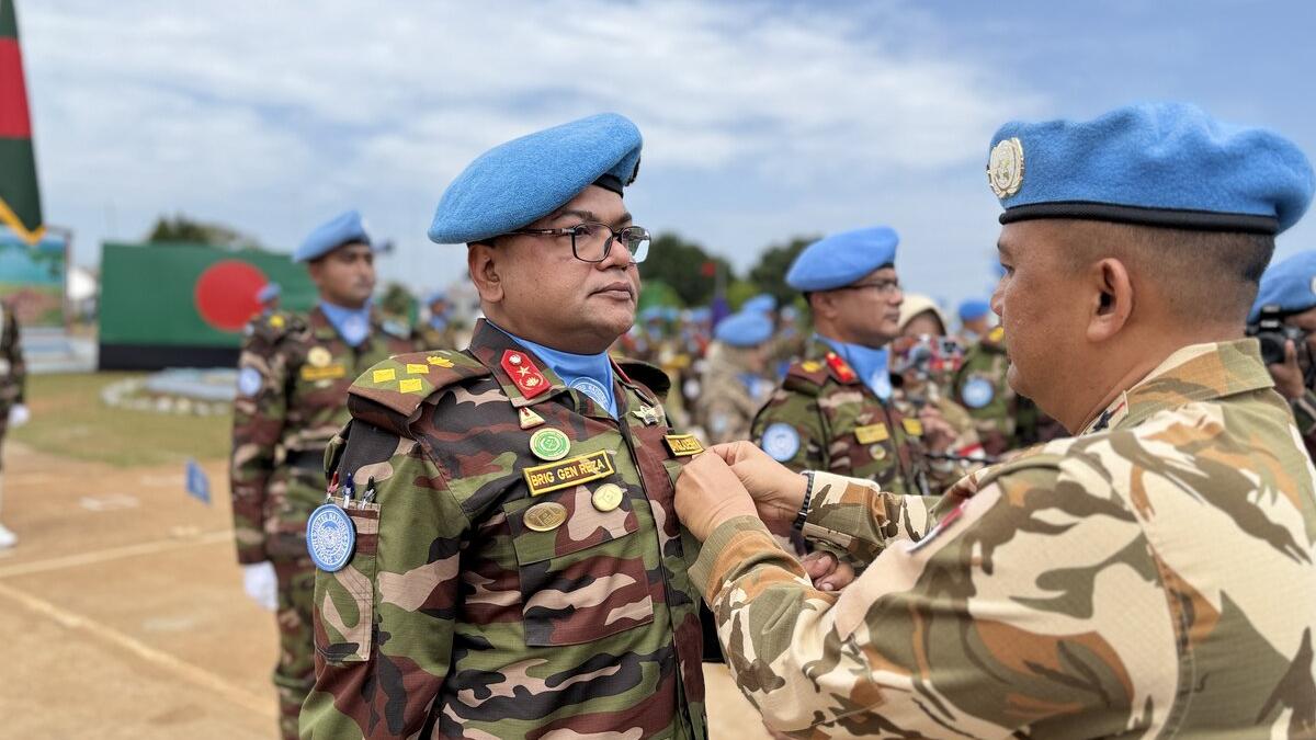 Un casque bleu reçoit une médaille. 