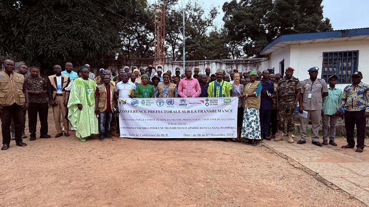 Des représentants se tiennent derrière une bannière commémorative.