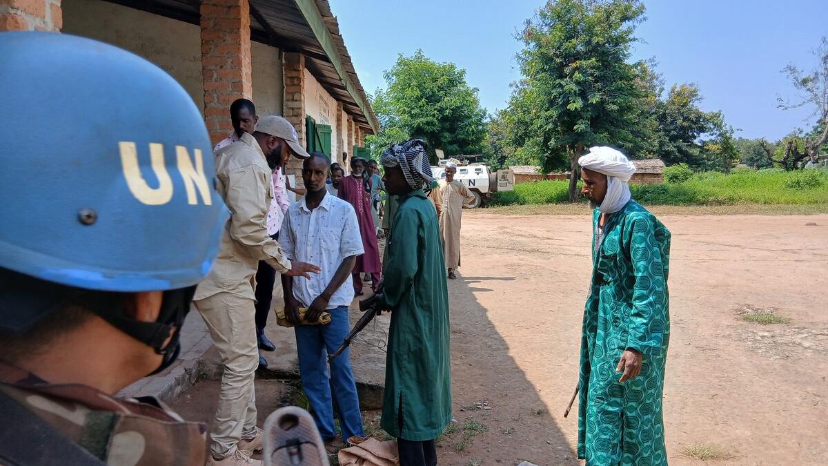 Un casque bleu et un représentant parlent avec d’anciens combattants.