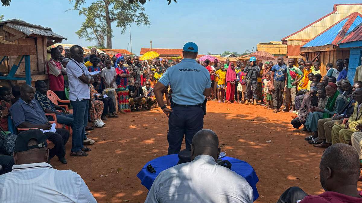 Un groupe se tient pour écouter un représentant de la Gendarmerie.