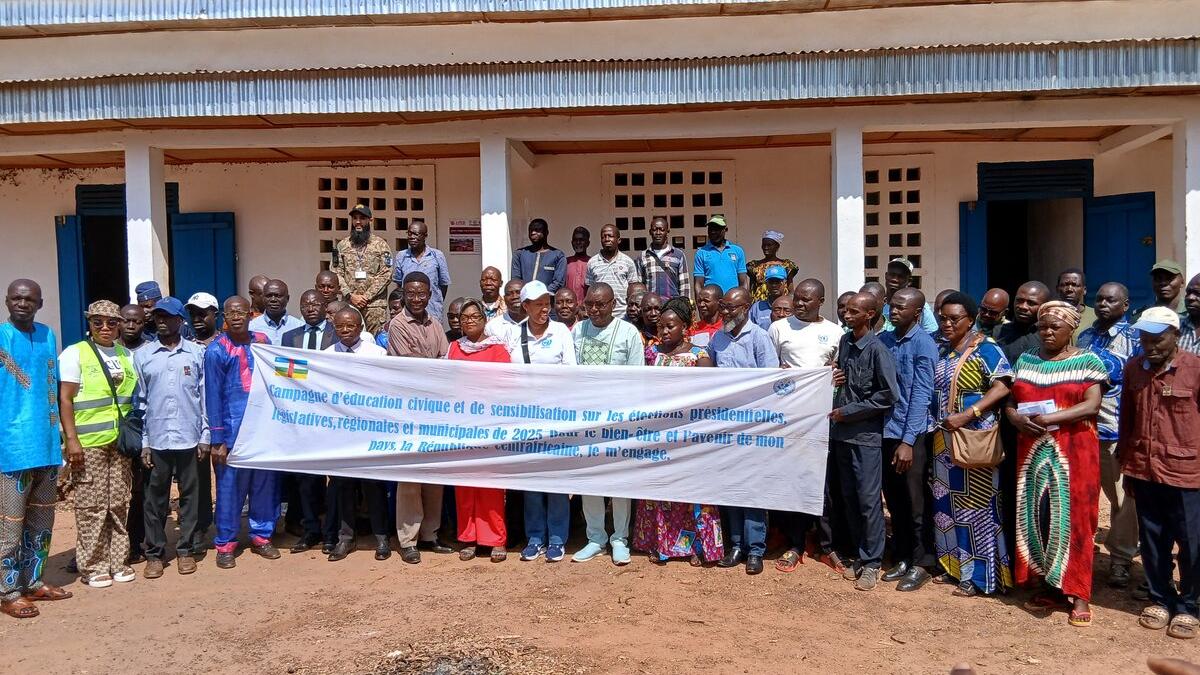 Un groupe de représentants tient une bannière en posant pour une photo commémorative.