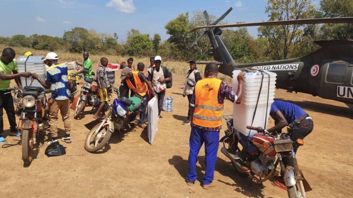Un groupe de personnes fixe des conteneurs de stockage sur des véhicules.