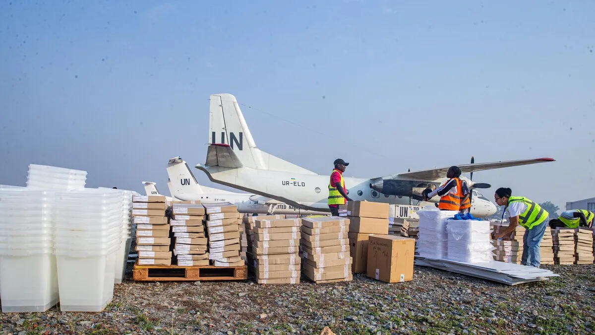 Des travailleurs trient des fournitures près d’un avion de l’ONU.