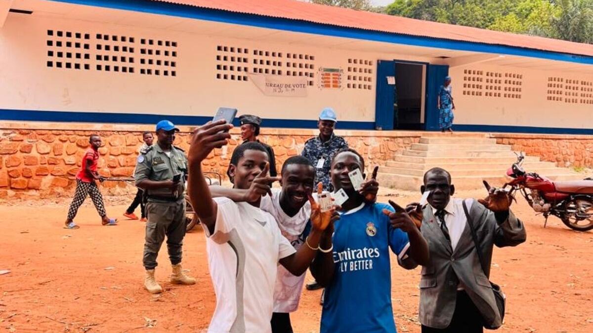 Un groupe de personnes prend une photo de groupe pour célébrer l'événement, en tenant leurs cartes d'identité.