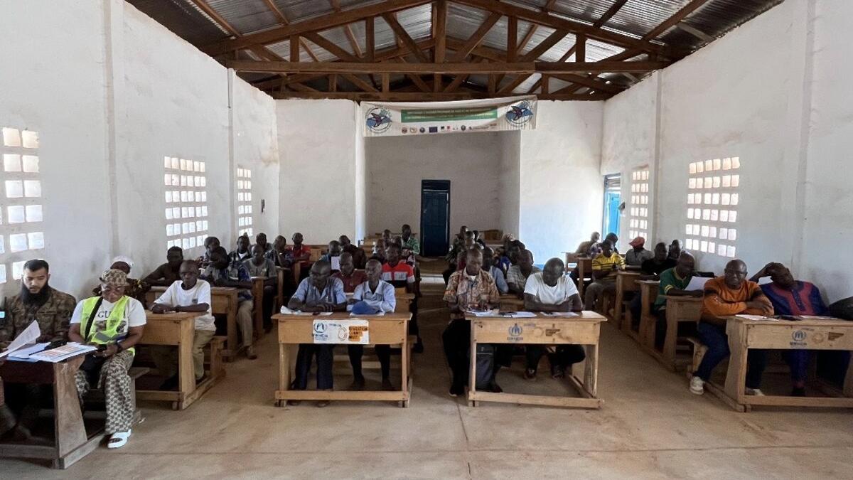 Un groupe de personnes est assis à des bureaux.