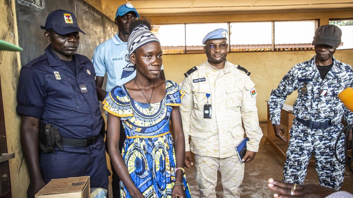 Des électeurs et des Casques bleus sont photographiés.