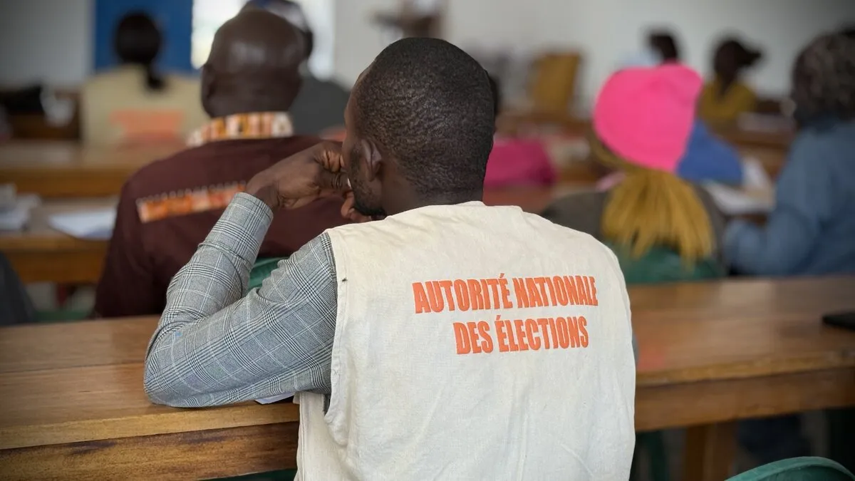 Un représentant porte une veste avec les mots « Autorité Nationale des Élections ». 