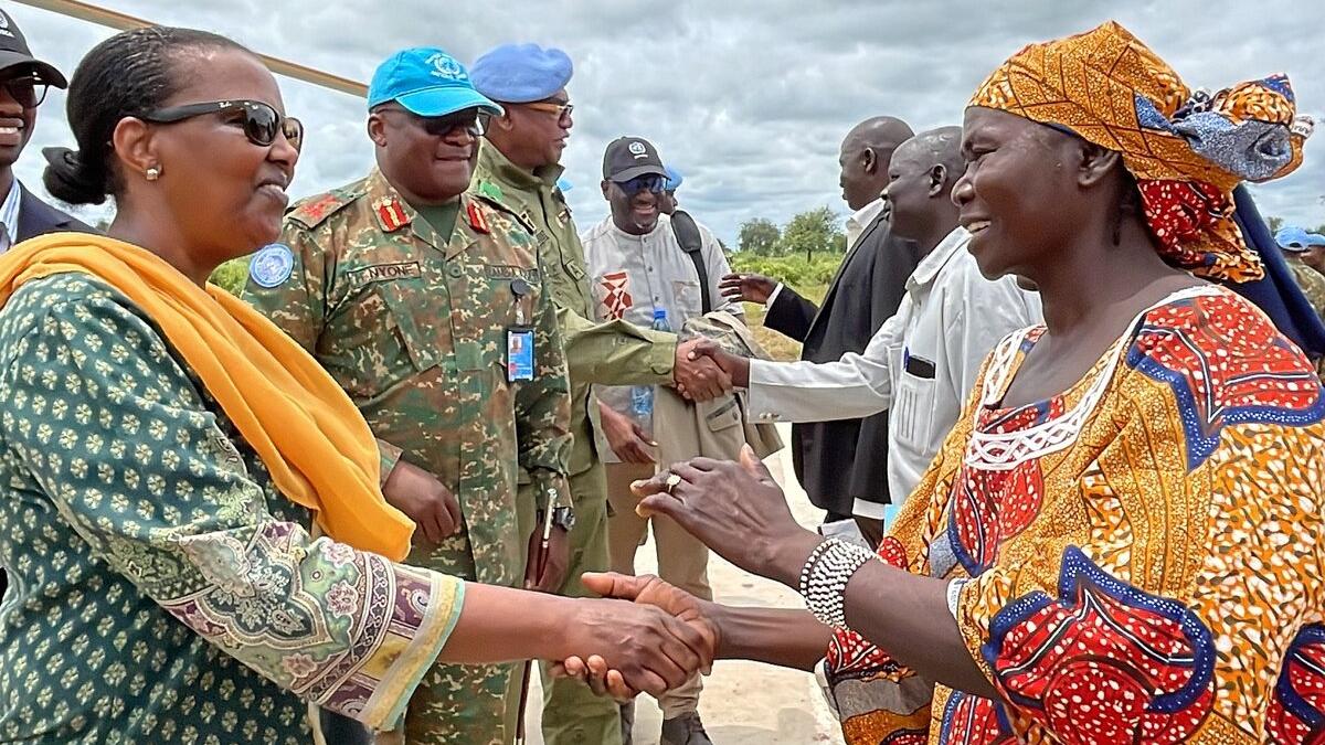 Valentine Rugwabiza et des casques bleus serrent la main de représentants.