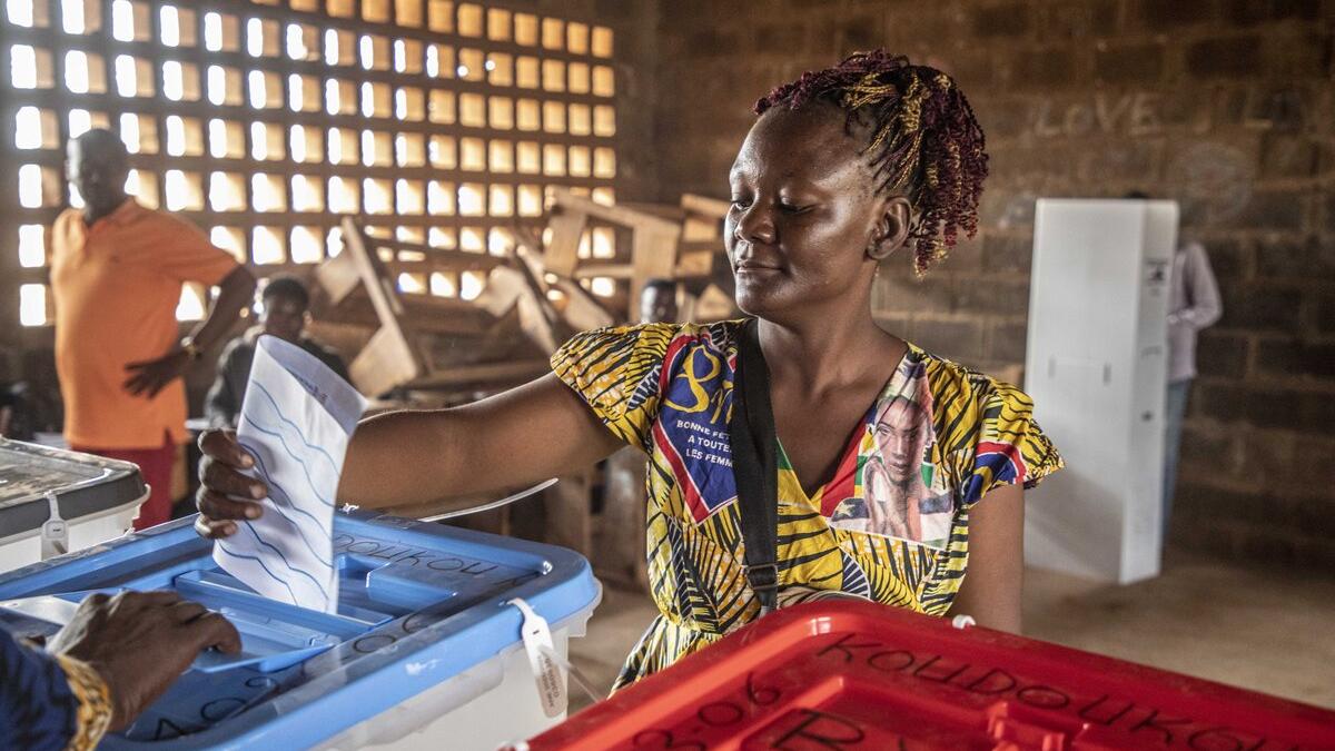 Un électeur dépose un bulletin dans une urne.