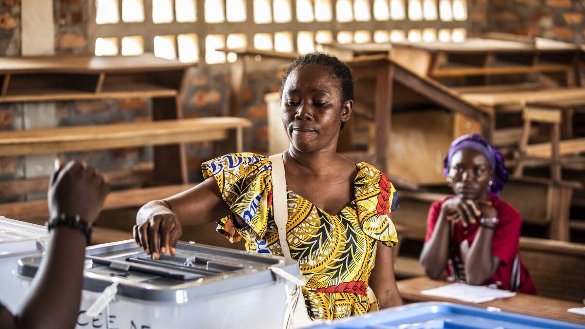 Un électeur dépose un bulletin dans une urne.