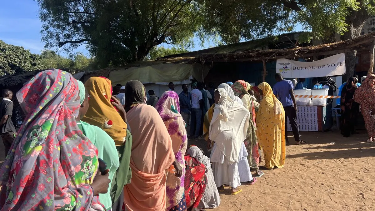 Des personnes font la queue devant un bureau de vote.