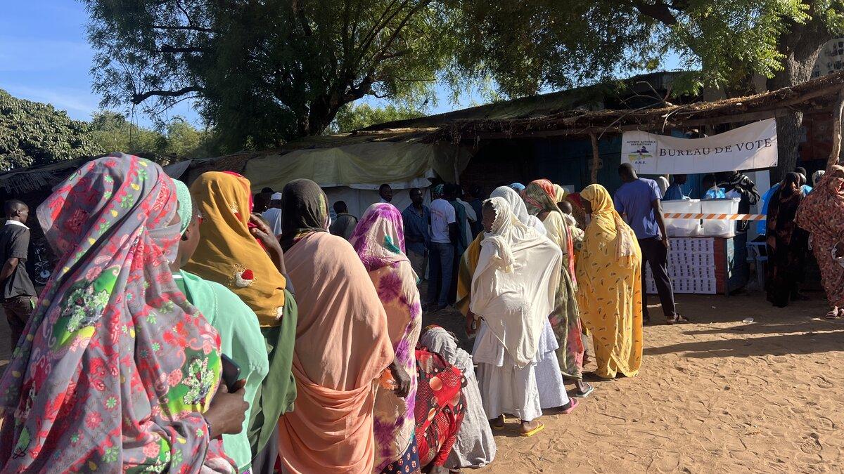 Des personnes font la queue devant un bureau de vote.