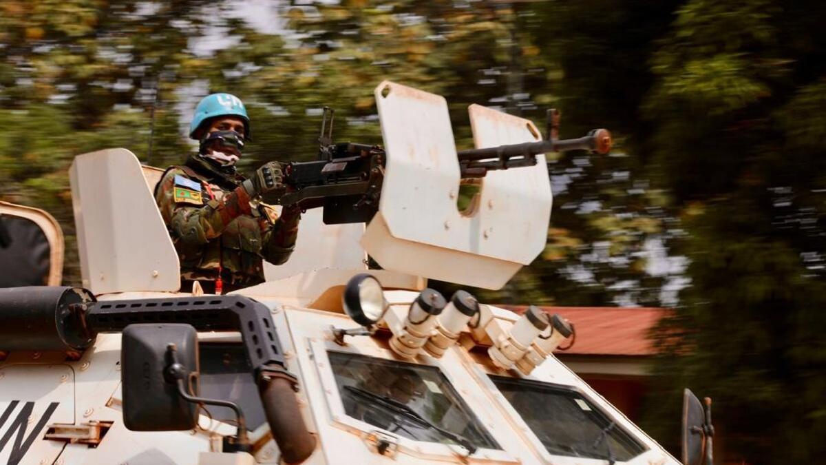 Un militaire armé est à bord d’un véhicule armé.