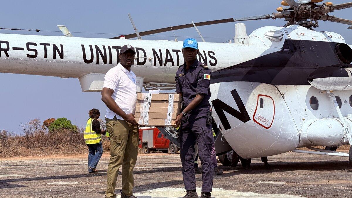 Des représentants de l’ONU transportent des fournitures depuis un hélicoptère de l’ONU.