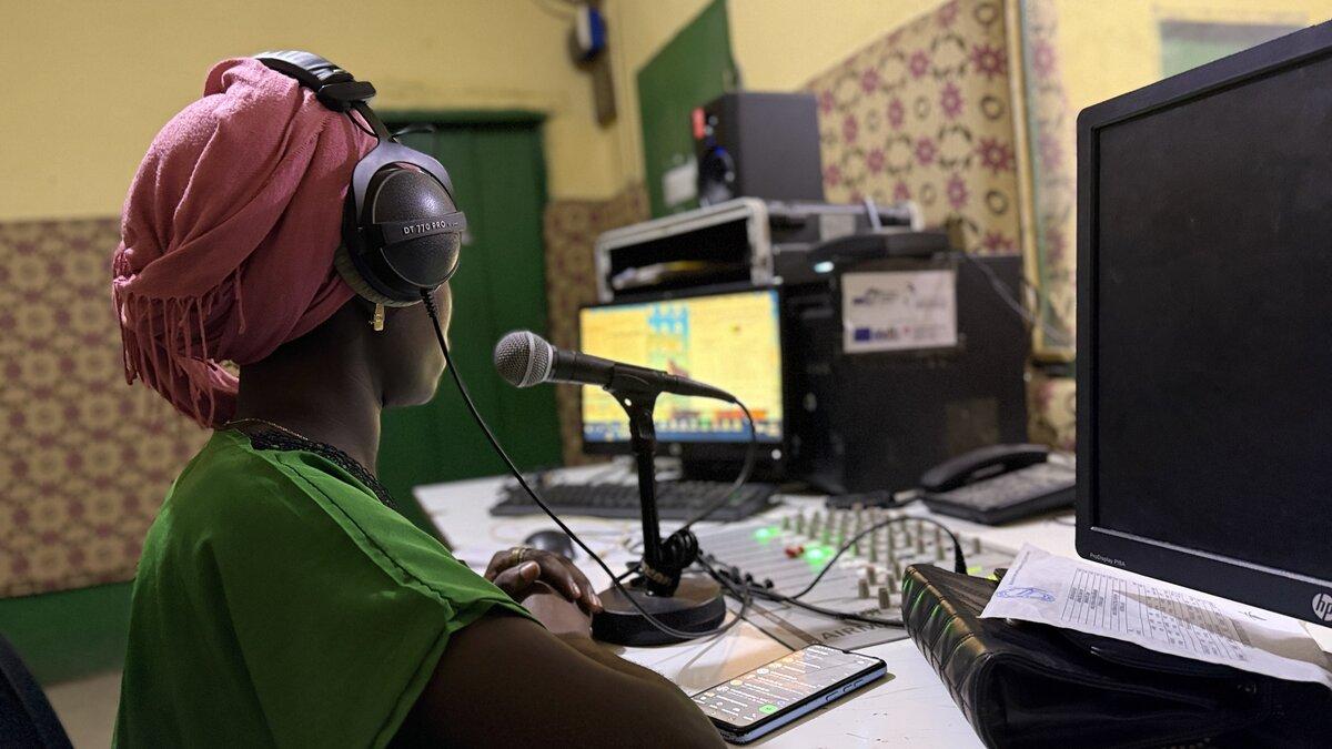 Une personne est photographiée avec un microphone dans un studio d’enregistrement.