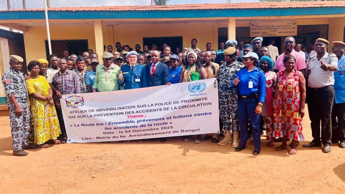 Des représentants se tiennent derrière une bannière commémorative.