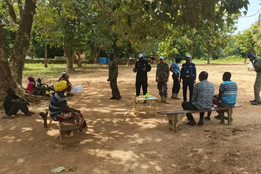 Des Casques bleus et des membres de la communauté tiennent une réunion sous un arbre