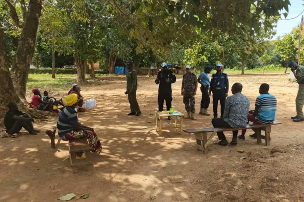Des Casques bleus et des membres de la communauté tiennent une réunion sous un arbre