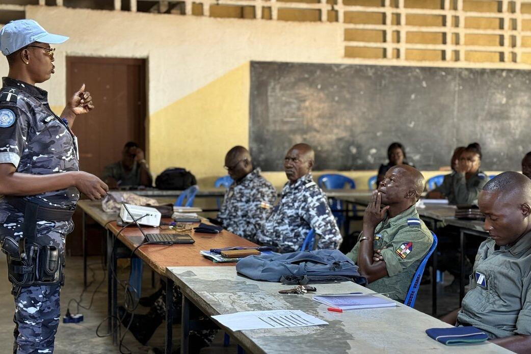 Une femme soldat de la paix en uniforme militaire s'adresse à une salle remplie de militaires.