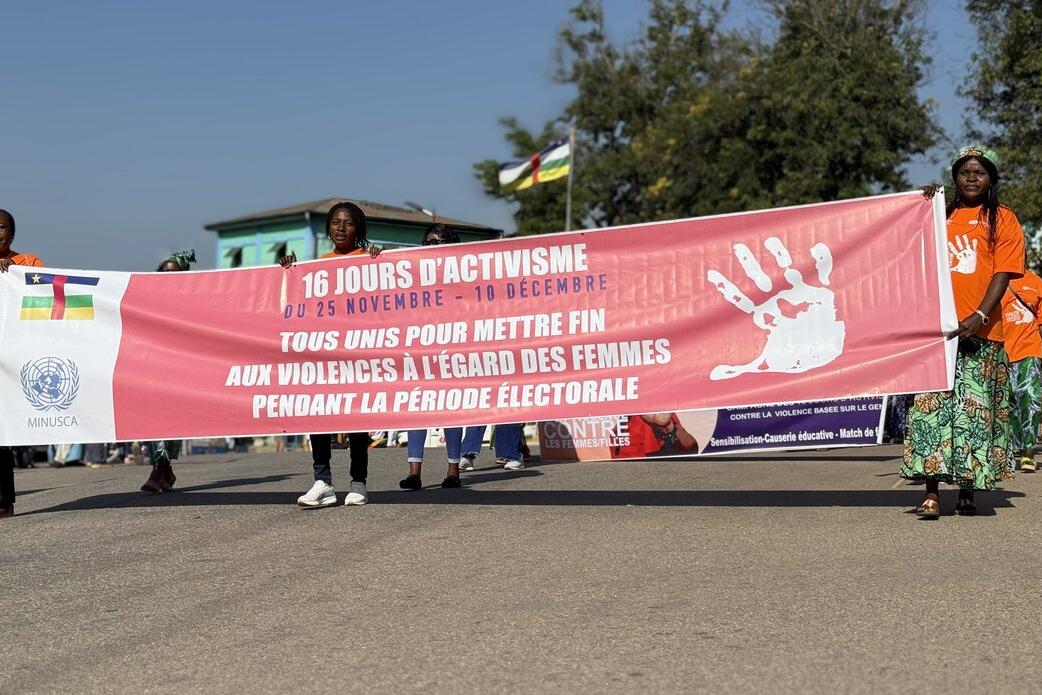 Des gens défilent avec une grande bannière