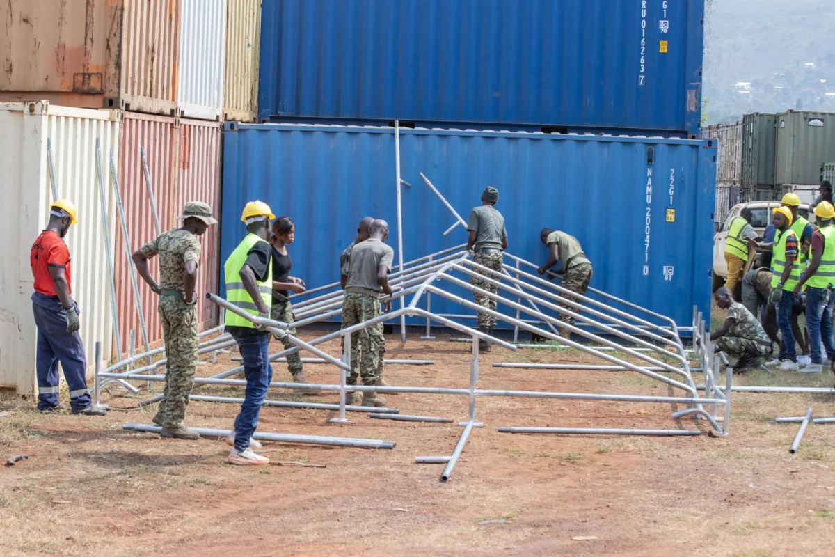 Many people working on a tent