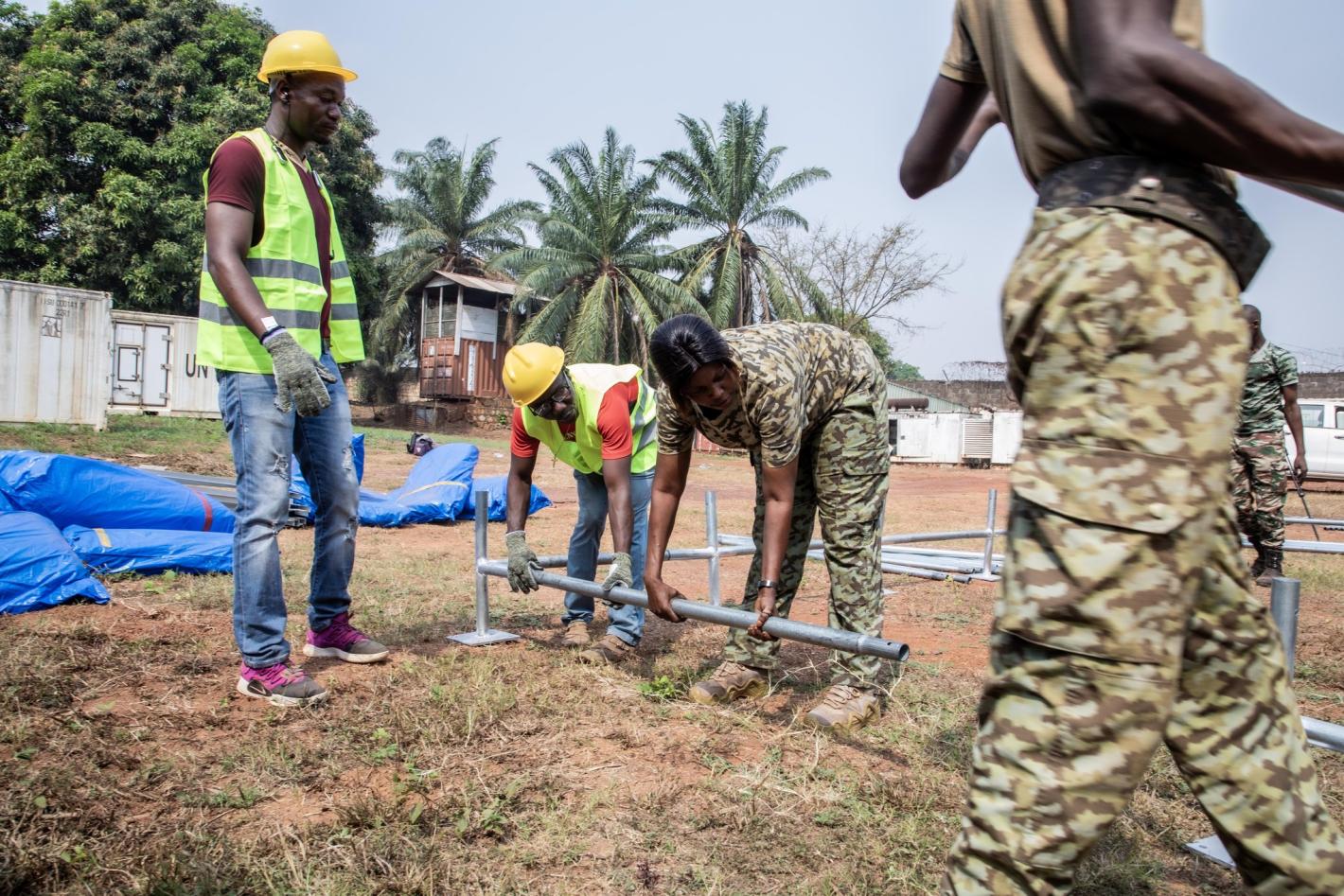 four people making a tent