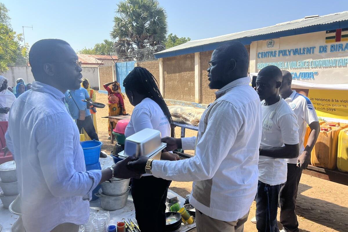 Des personnes échangent des aliments et du matériel de cuisine.
