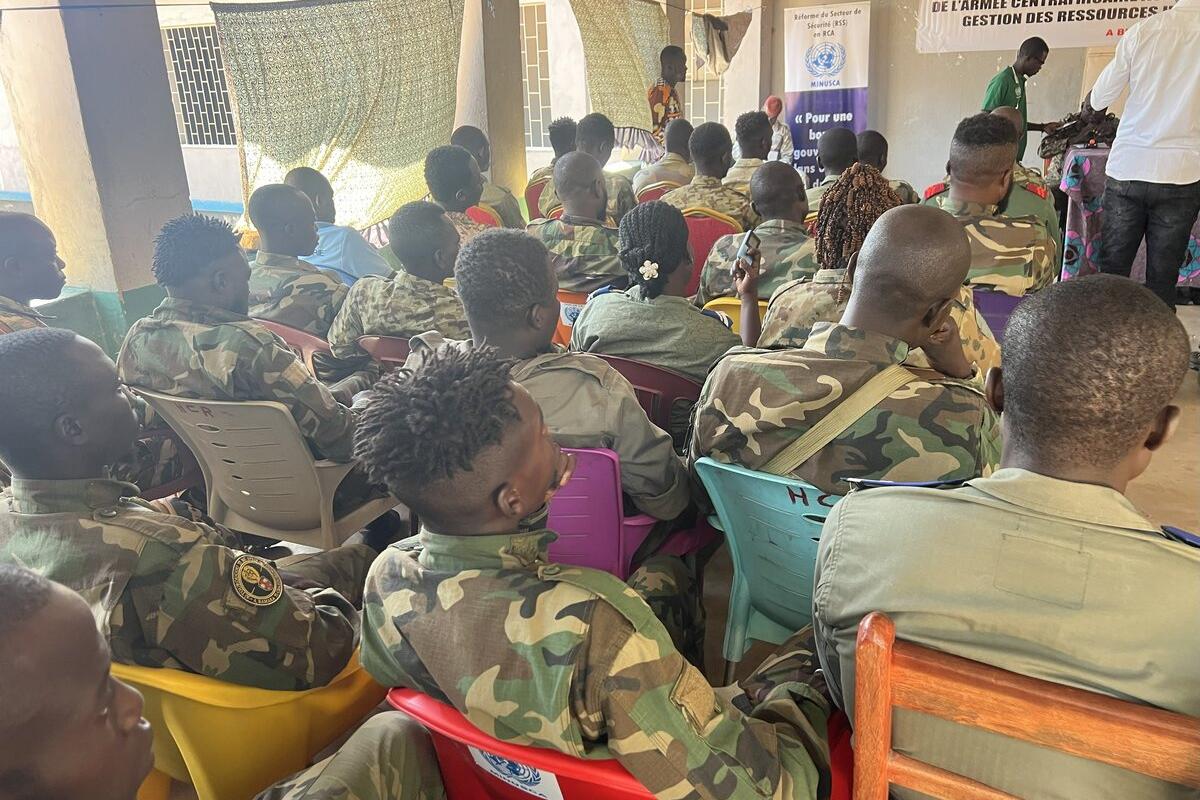 Des casques bleus sont assis pendant un événement. 