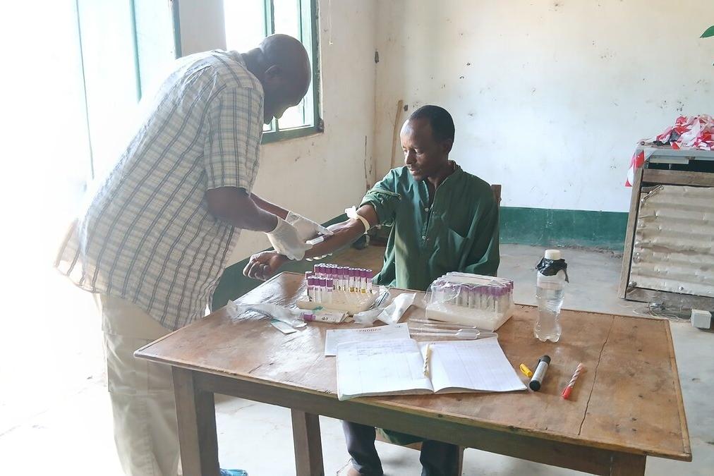 Un médecin prélève du sang à un patient.