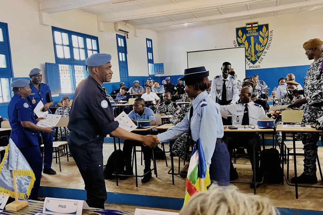 Deux forces de sécurité intérieure se serrent la main.