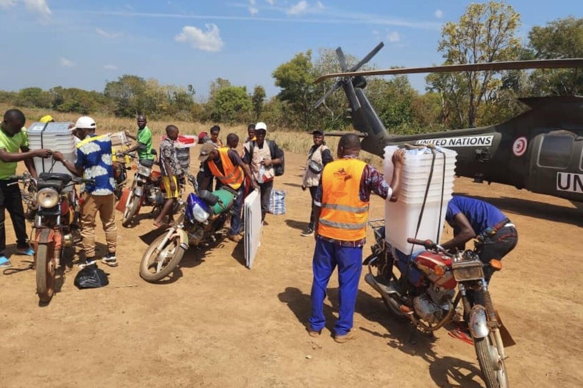 Un groupe de personnes fixe des conteneurs de stockage sur des véhicules.