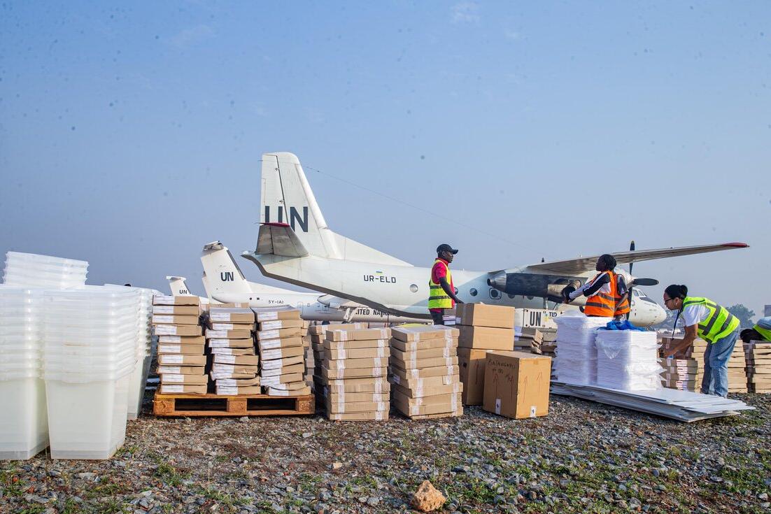 Des travailleurs trient des fournitures près d’un avion de l’ONU.