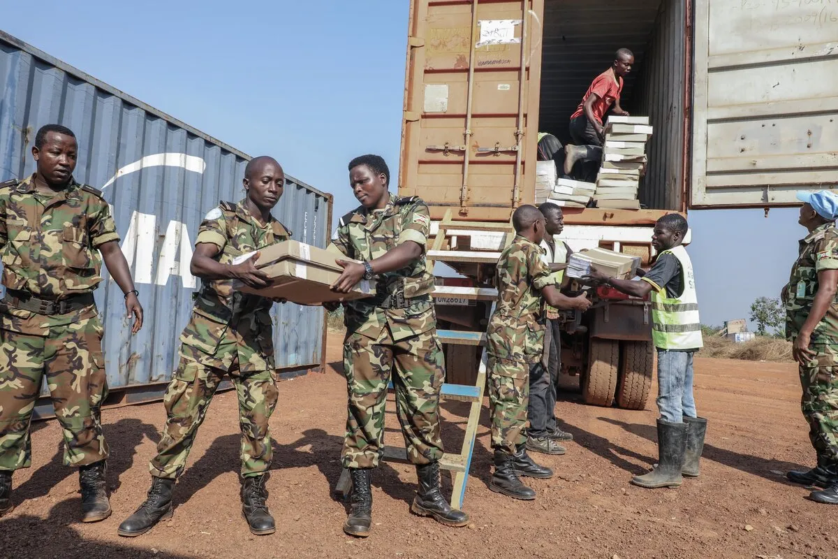 Des Casques bleus transportent des fournitures depuis un véhicule‑conteneur.