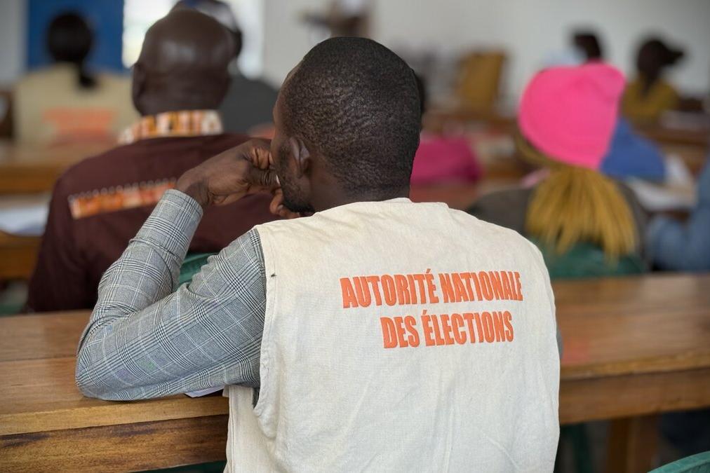 Un représentant porte une veste avec les mots « Autorité Nationale des Élections ». 