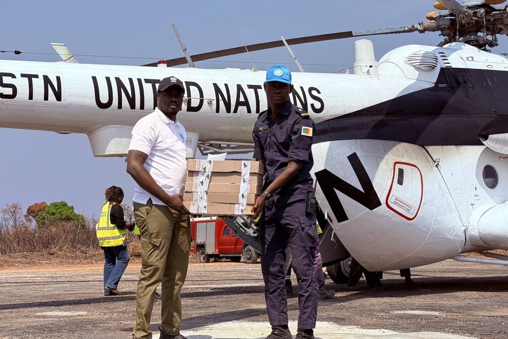 Des représentants de l’ONU transportent des fournitures depuis un hélicoptère de l’ONU.