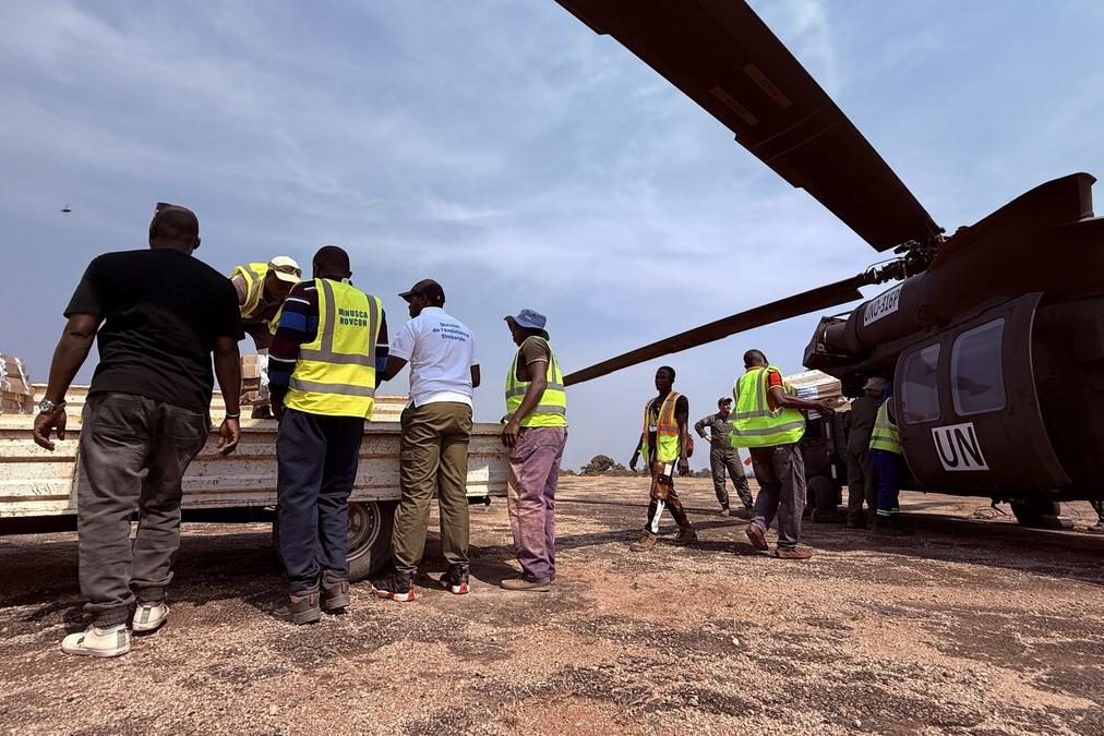 Des représentants de l’ONU transportent des fournitures depuis un hélicoptère de l’ONU.