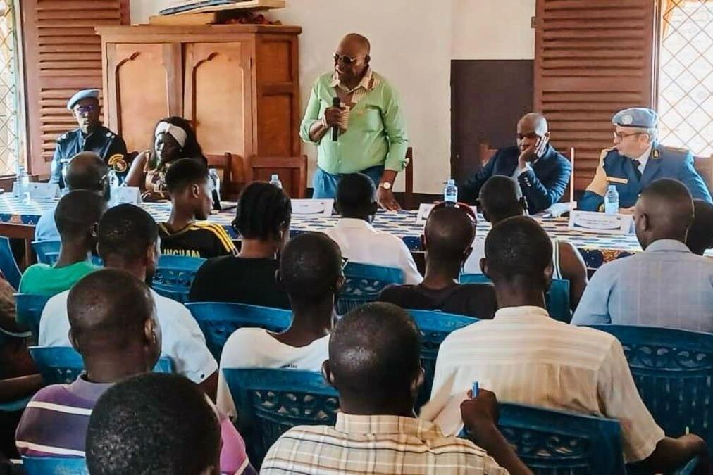 Un intervenant parle à un public assis.