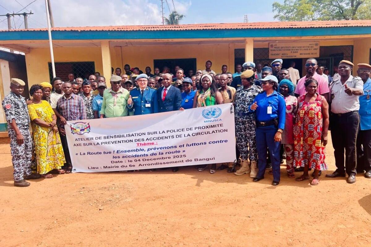 Des représentants se tiennent derrière une bannière commémorative.