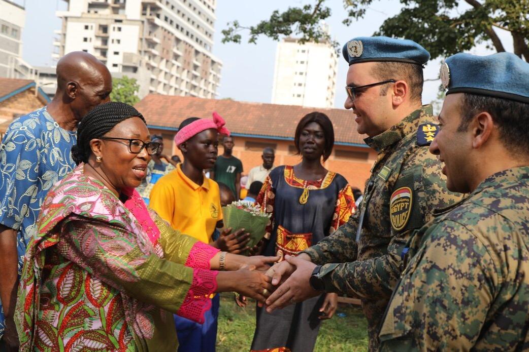 Une femme serre la main des Casques bleus de l'ONU.